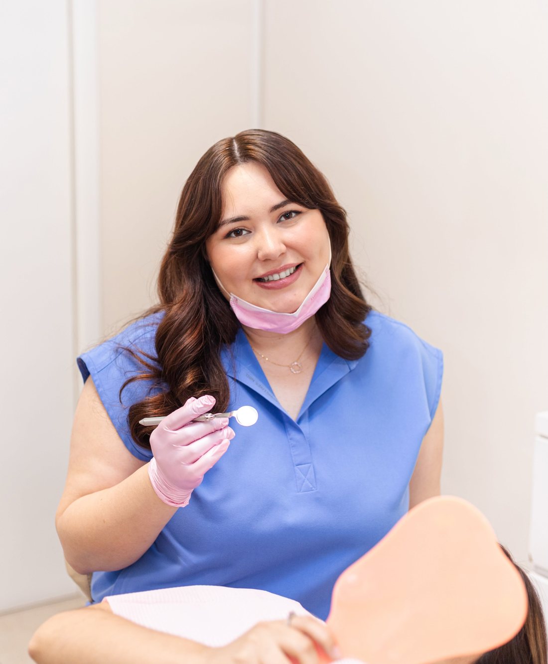 Dra. Melissa de Dentálite sonriendo con espejo dental
